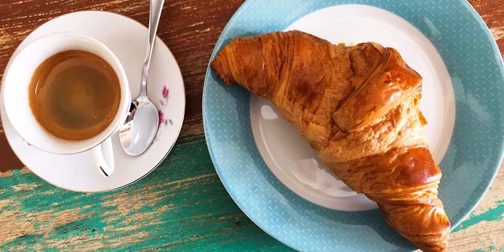 Maslový croissant s kávou