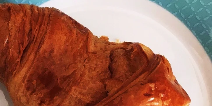 Maslový croissant s kávou